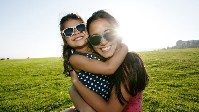Une mère et sa fille souriant à la caméra