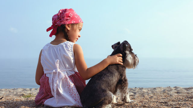 Une petite fille avec son chien regardant dans le vide
