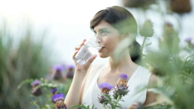 Une fille buvant de l'eau dans un jardin